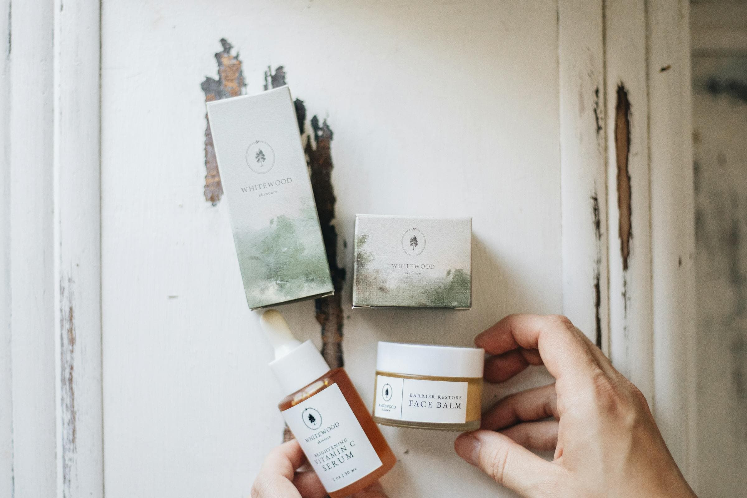 Natural botanical ingredients arranged thoughtfully — rosehip, jojoba, and golden oils catching warm light