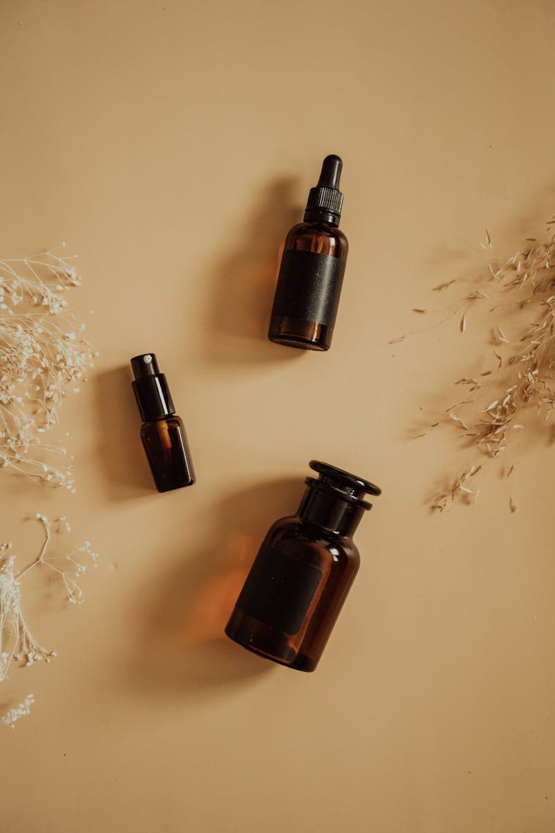 Amber skincare bottles with dried floral accents